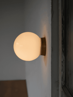 Aura Globe Glass Wall Sconce in Brass for Modern Interiors