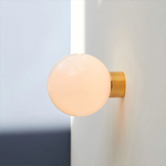 Aura Globe Glass Wall Sconce in Brass for Modern Interiors