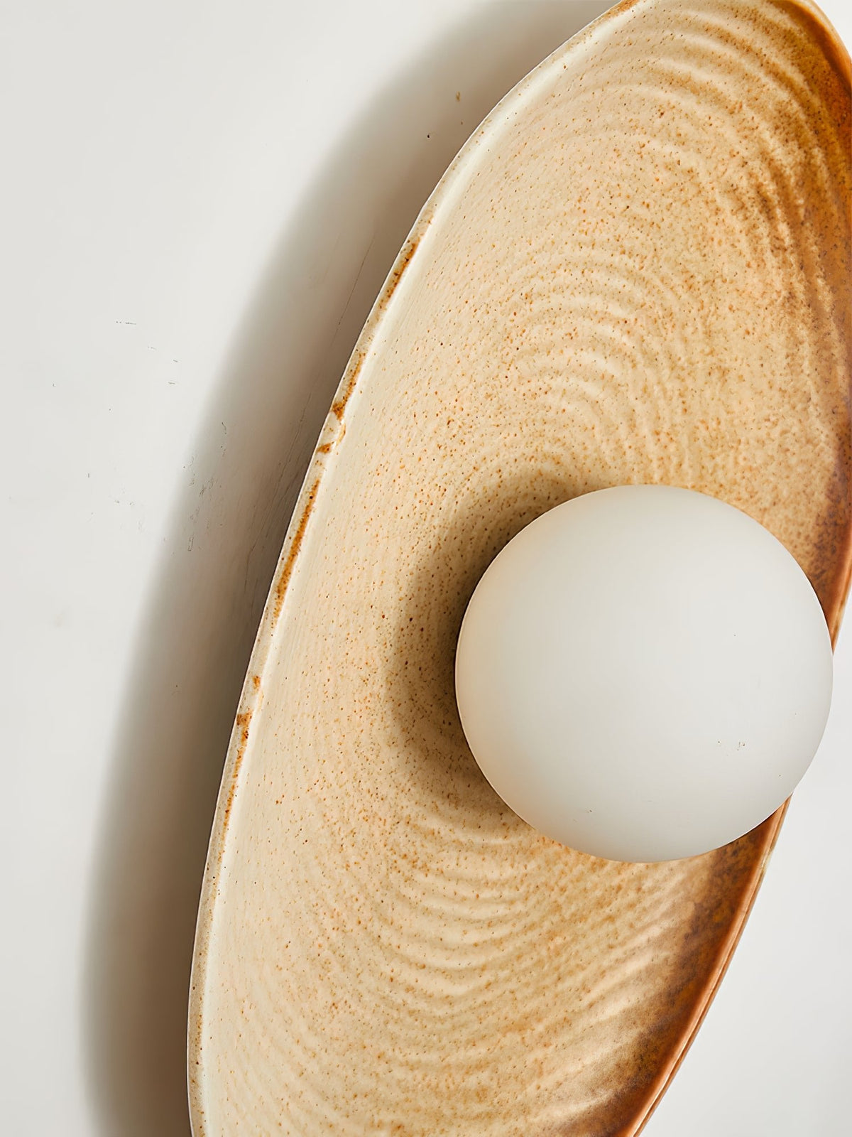 Solstice Swirl Ceramic Wall Sconce with Glowing Orb