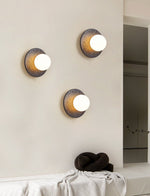 Crater Backlit Wall Sconce in Black Travertine with Opal Glass Globe