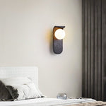 Eclipse Orb Wall Sconce in Black Travertine with Opal Glass Shade