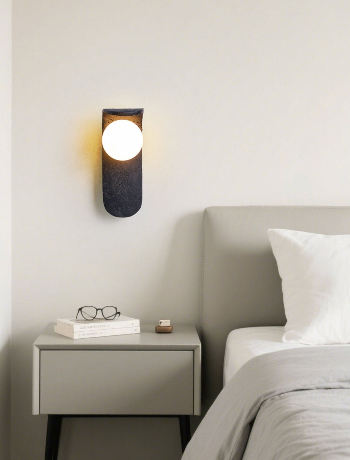 Eclipse Orb Wall Sconce in Black Travertine with Opal Glass Shade