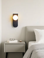 Eclipse Orb Wall Sconce in Black Travertine with Opal Glass Shade