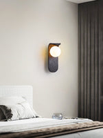 Eclipse Orb Wall Sconce in Black Travertine with Opal Glass Shade