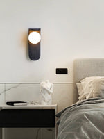 Eclipse Orb Wall Sconce in Black Travertine with Opal Glass Shade