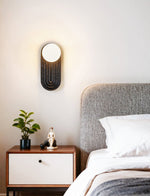 Eventide Orb Wall Sconce in Black Travertine with Opal Glass Globe