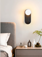 Eventide Orb Wall Sconce in Black Travertine with Opal Glass Globe