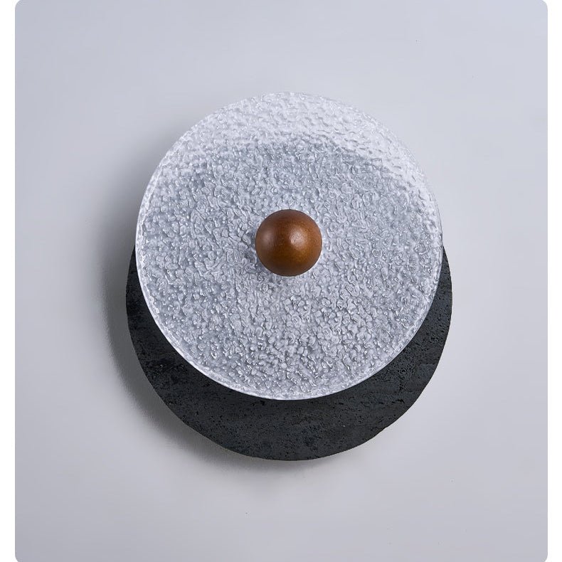 Lunara Textured Disc Wall Sconce in Black Travertine and Frosted Glass